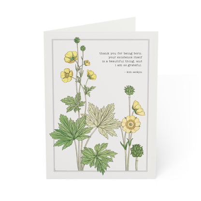 Greeting card with botanical illustration of yellow flowers and green leaves on a white background.