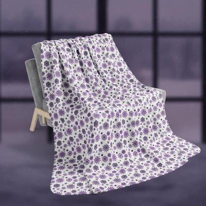 Snowflake patterned blanket draped over a chair on a white background