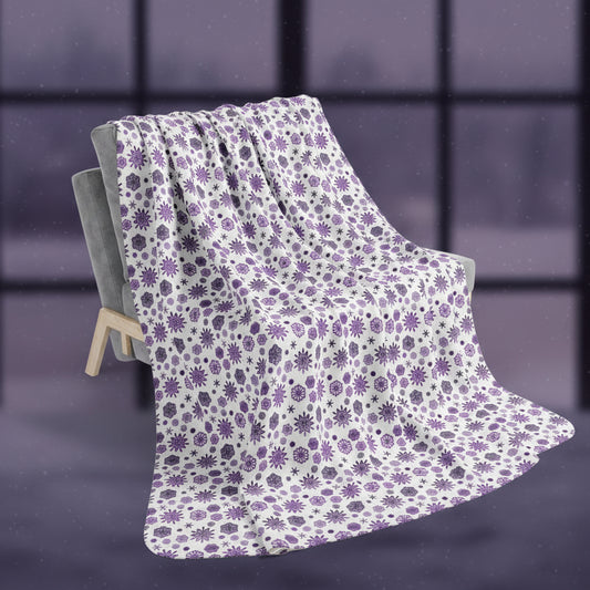 Snowflake patterned blanket draped over a chair on a white background
