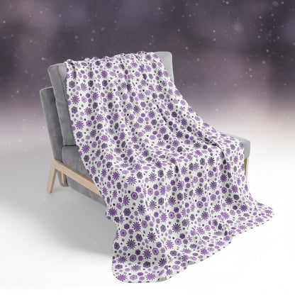Snowflake-patterned blanket draped over a chair in a snowy landscape