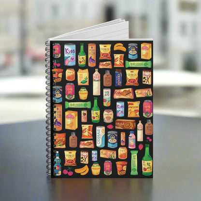 Notebook with colorful product illustrations on a black background